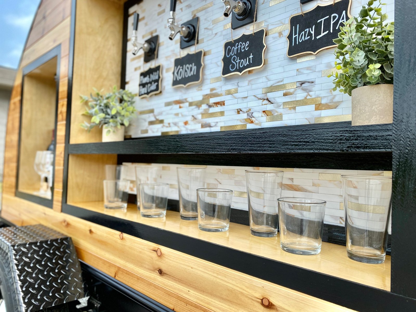 A close up of the tap trailer's tap handles, menu signage and glassware