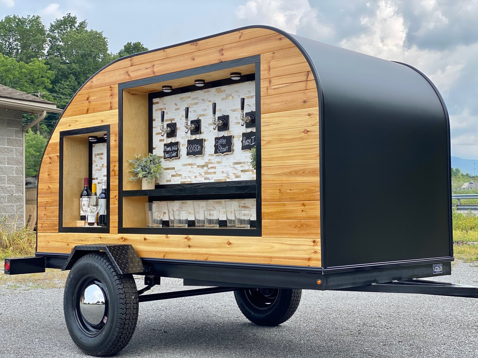 The Tonic and Timber tap trailer parked outside with taps, glassware and wine bottles on display