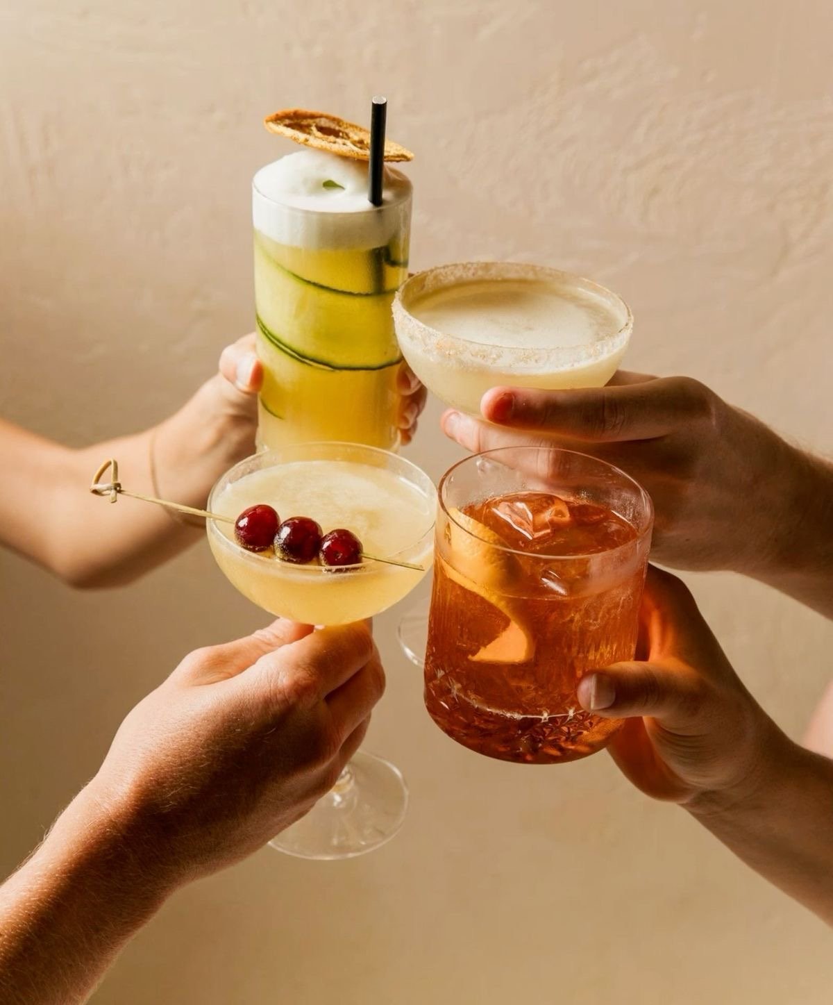 Friends raising a toast with handcrafted cocktails from Tonic and Timber