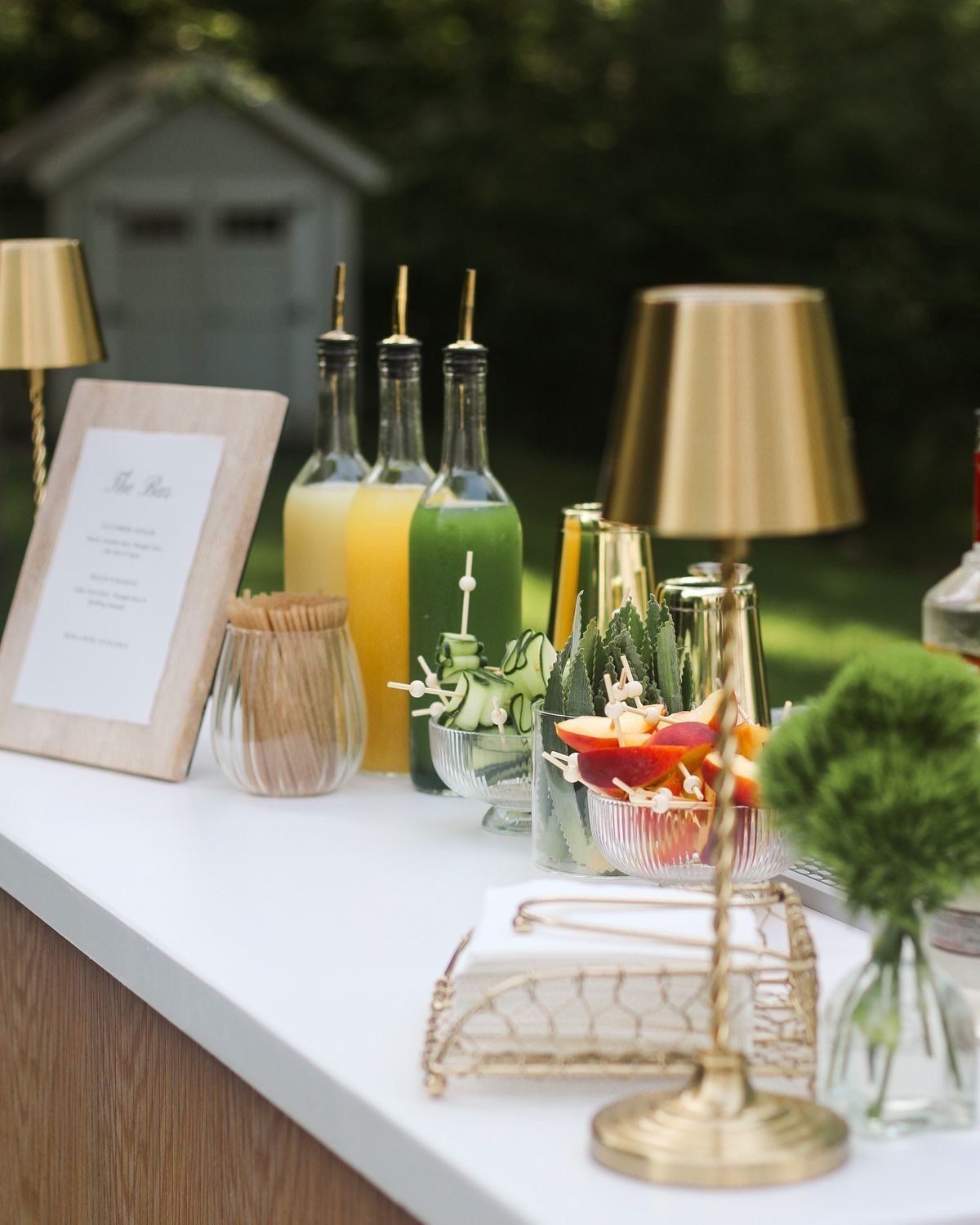 A styled Cedar Bar setup with fresh juices, fruit garnishes and brass accents