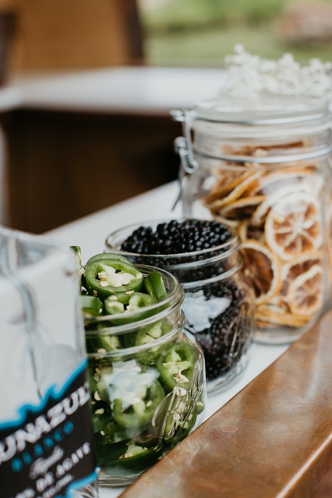 Garnish jars of jalapeno, blackberries and dried citrus on the Cedar Bar