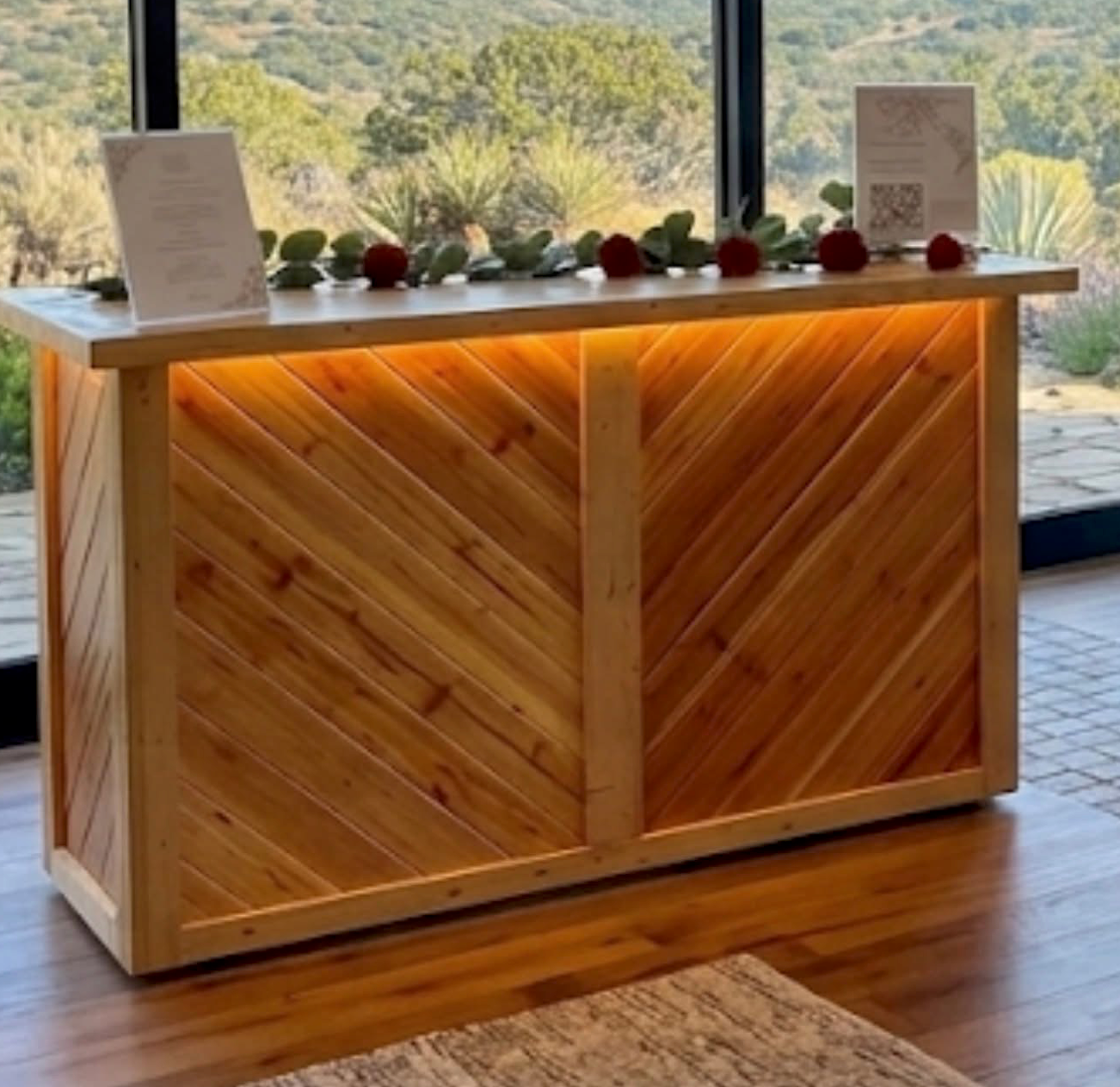 The handcrafted Cedar Bar set up with roses and menu cards in front of a mountain view